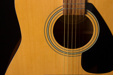 acoustic guitar on a black background. close-up.