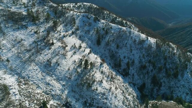 Mountainous scenery, snow covered slope, fly over drone view