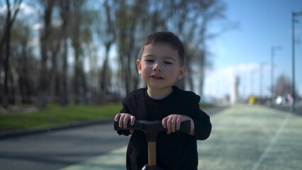 A Joyful Young Child Happily Riding a Colorful Scooter in the Park, Embracing Fun and Adventure
