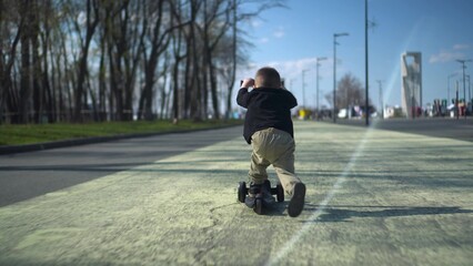 A joyful child happily riding a bright scooter in a sunny park filled with greenery and laughter