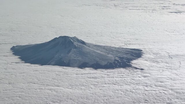 4k aerial video footage - flying along Jan Mayen island (northeast of part) a volcanic island in Arctic Ocean with Volcano "Beerenberg" and highest summit "Haakon VII Toppen"- parts coved with clouds 