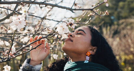 Outdoor, woman and flower in nature with blossom, gratitude and peace in garden. Wellness, female person and spring season in park with zen, happiness and appreciation for green tree environment.