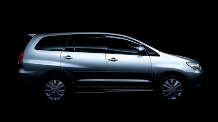 Sleek silver MPV showcased against a dramatic black background, highlighting its modern design and clean lines for automotive advertising.