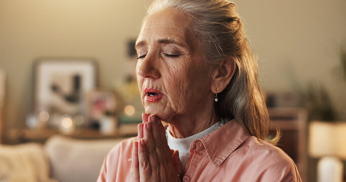 Belief, hope and prayer with senior woman on sofa in living room of home for trust in Christ Jesus. Faith, religion and worship with old person praying to God for confession, forgiveness or guidance