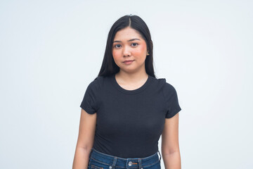 A peaceful young Asian woman in a half body shot wearing a soft smile with a warm and serene look...