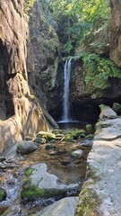 Picturesque Nature Trail: Serene European Hills with Flora, Rocks, and Flowing River