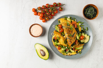 Pancakes with seaweed. Served on a plate with avocado and tomatoes.