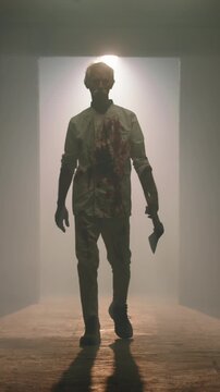 Frightening bloody axe man in dirty pajamas walking narrow dark haunted hallway with fog flickering light slow motion cinematic horror halloween spooky nightmare slasher atmosphere