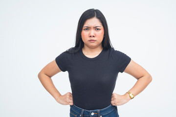 An infuriated young Asian woman in a half body shot with her hands on her waist, showing a confrontational stance and fierce expression. Isolated on a white background.