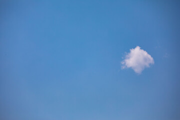 Rare scene with small white cloud isolated on blue sky background, free space for text