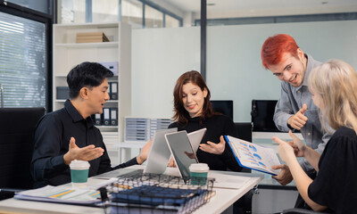 Financial analysts work overtime analyzing data on tablets, laptops, and graphs. Collaboration, teamwork, and planning.