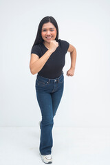 An eager young Asian woman in a full body shot running forward with one hand raised and the other foot in motion, smiling happily with energy. Isolated on a white background.