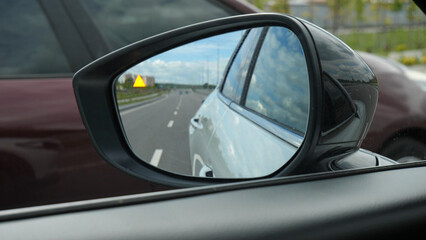 The blind zone sensor signal lights up in the car mirror when another car overtakes it
