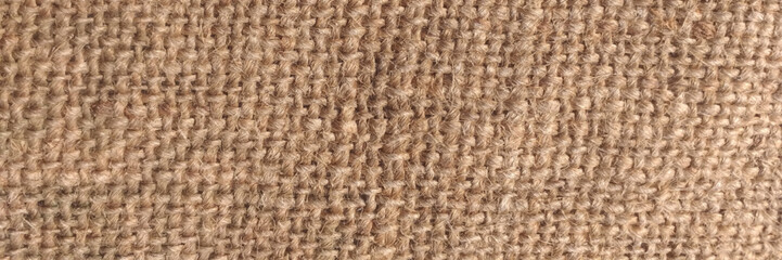 Jute hessian sackcloth woven organic burlap, hemp flax texture pattern background in light cream yellow beige brown color. Texture of burlap