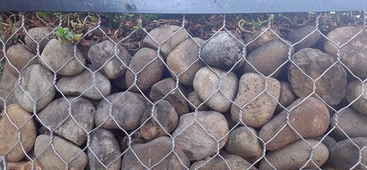 Gabion coral stones wall texture background in metal wire