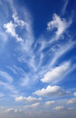 Obraz premium A bright, airy sky filled with wispy cirrus clouds blending into puffy cumulus formations, under a vibrant blue, summer day