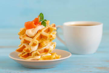 Waffles with cream cheese and smoked salmon for tasty breakfast.