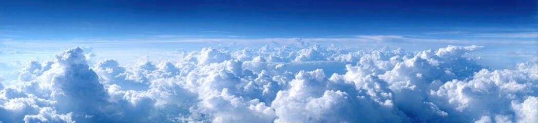 Vast expanse of puffy white clouds under a bright blue sky, aerial view. Airy atmosphere with depth