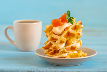 Waffles with cream cheese and smoked salmon for tasty breakfast.