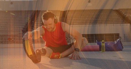Male athlete grabbing prosthetic blade strap and deepening hamstring stretch during sunset fitness - Powered by Adobe