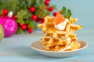 Waffles served with salty salmon and cream cheese for Winter holidays, for Christmas.