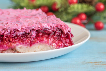 Russian Salad Herring Under The Fur Coat made of salty herring, boiled potato, beetroot, mayonnaise. Salad for Winter holidays, for New Year on blue background.
