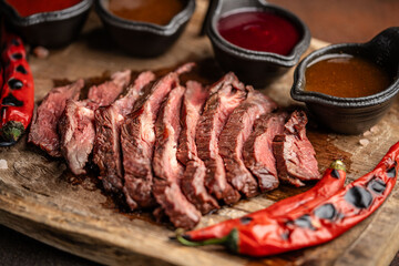 grilled beef steak with sauces and chili peppers
