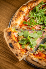 Italian pizza with arugula and ham.
