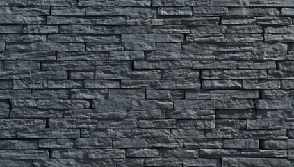 Fototapeta premium A full view of a dark gray stone wall, featuring rectangular blocks arranged in a grid pattern, exhibiting natural stone textures.