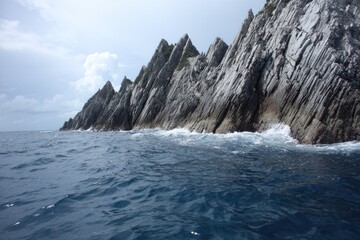 Naklejka premium Dramatic coastal scenery showcasing a rugged shoreline with layered rock formations meeting the ocean waves.