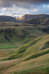 A vast, rugged landscape with volcanic mountain ranges and Mýrdalsjökull icecap in the background in the south of Iceland
