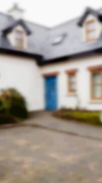 Animation of silver house key fob and key, hanging in front of blurred house with for sale sign