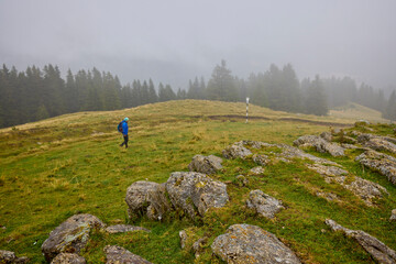 a middle-aged man climbing a mountain on a cloudy and foggy day