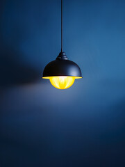 Pendant lamp glowing warmly against cool tones for teaching design balance and visual mood
