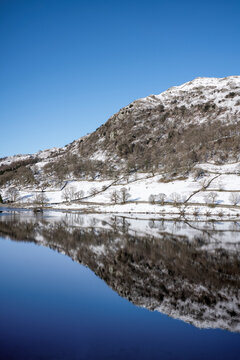Reflections of snow covered hill at Rydal Water in the Lake District National Park, United Kingdom