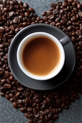 Fototapeta premium Heart-shaped coffee arrangement with espresso in black cup on coffee beans background