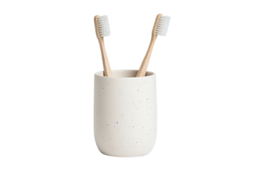 A stylish ceramic toothbrush holder with two eco-friendly bamboo toothbrushes on a white isolate background.