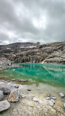 Austria, 08-2025 : wide shot of a glacial lake, near the weißsee lake. Moutains and cloudy sky in background.