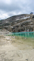 Austria, 08-2025 : wide shot of a glacial lake, near the weißsee lake. Moutains and cloudy sky in background.