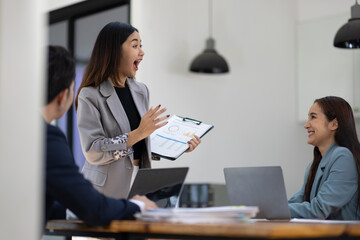 Asian businesswoman leader discussing business planning idea presentation with colleagues in conference room at office.
