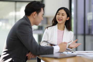 Group businesspeople happy while collaborating on a new project in an office. Businessman leading a discussion during a meeting with colleagues. Businesswoman interacting with a colleague.