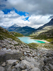 Austria, 08-2025 : wide shot of Weißsee lake, mountains and glaciers in background, mountain rocks in foreground.