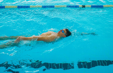 Swimmers training in the pool. Backstroke style. Sports, determination and endurance. Swimming...