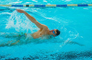Swimmers training in the pool. Backstroke style. Sports, determination and endurance. Swimming...