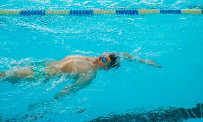 Swimmers training in the pool. Backstroke style. Sports, determination and endurance. Swimming...