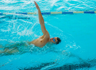 Swimmers training in the pool. Backstroke style. Sports, determination and endurance. Swimming competitions.