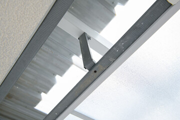 Precise construction detail of metal support for transparent awning during house renovation project. sturdy framework shows modern building technique and design