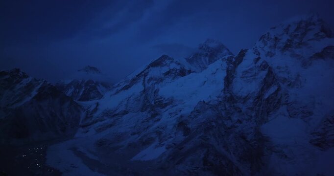 Aerial drone view of Khumbu Glacier at night from Gorakshep on Everest Base Camp trek, Sagarmatha, Nepal. Snowy mountain ranges glow in moonlight, revealing Sherpa village life and Himalayan scenery