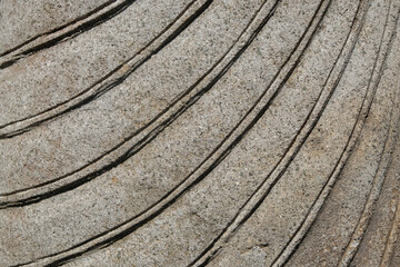 Background texture and curved striped pattern of stone body carving. Detail of carving on stone statue