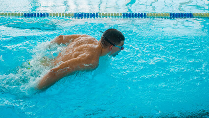 Professional Swimmer Performing Butterfly Stroke – Speed, Power and Determination. Swimming...